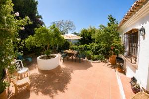 a patio with a table and an umbrella at El Remanso de Marie in Órgiva