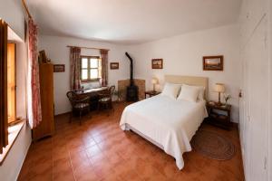 a bedroom with a white bed and a desk at El Remanso de Marie in Órgiva