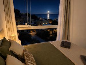 a bedroom with a large window with a view of the ocean at Luz y calma junto al mar in Lagos