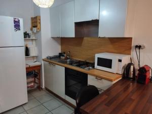 a kitchen with a white refrigerator and a microwave at Small, well-equipped apartment, Chabat elevator in Giv‘at Shemuʼel