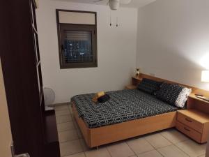 a bedroom with a bed with a teddy bear on it at Small, well-equipped apartment, Chabat elevator in Giv‘at Shemuʼel