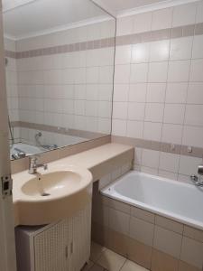 a bathroom with a sink and a bath tub at Small, well-equipped apartment, Chabat elevator in Giv‘at Shemuʼel