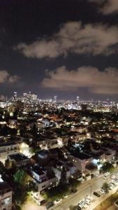 a view of a city at night with lights at Small, well-equipped apartment, Chabat elevator in Giv‘at Shemuʼel