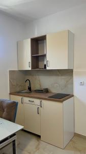 a kitchen with white cabinets and a sink at Apartmani Tajra in Donji Štoj