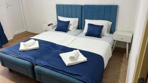 a blue and white bed with two pillows on it at Apartmani Tajra in Donji Štoj