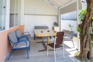 a table and chairs on a patio with an umbrella at Apartmani Šarkinović in Sutomore