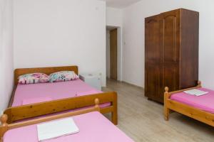 a room with two beds and a cabinet at Apartmani Šarkinović in Sutomore