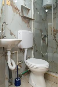 a bathroom with a toilet and a sink at Apartmani Šarkinović in Sutomore