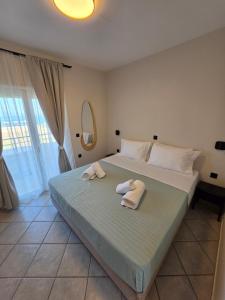 a bedroom with a bed with towels on it at Magenta Beach in Porto Heli