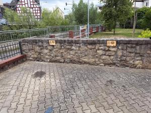 a stone wall next to a brick sidewalk at Diezer Apartments II City in Diez