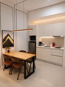 a kitchen with a wooden table and chairs at Chambers Elite Suites KLCC in Kuala Lumpur