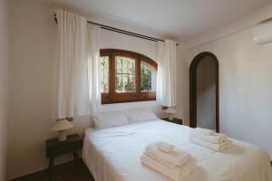a bedroom with a white bed with towels on it at Villa Pony in Calonge +40 photos