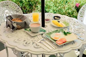 a white table with breakfast food and a glass of orange juice at Casa Provenzal Hotel Boutique in Villa de Leyva +66 photos