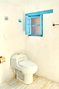 a bathroom with a toilet and a blue window at Casa Provenzal Hotel Boutique in Villa de Leyva