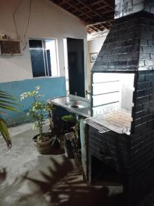 a kitchen with a brick fireplace and a sink at Vila Sol & Mar Gaibu PE in Cabo de Santo Agostinho