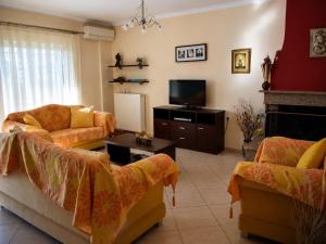 a living room with two couches and a tv at Vasw Apartment in Ágios Nikólaos