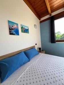 a bedroom with a white bed with blue pillows at Villa Alelida in Cinisi