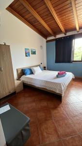 a bedroom with a large bed with a wooden ceiling at Villa Alelida in Cinisi