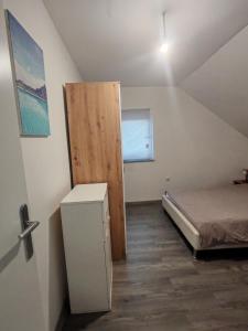 a small room with a bed and a wooden door at Apartmani Mila in Brlog