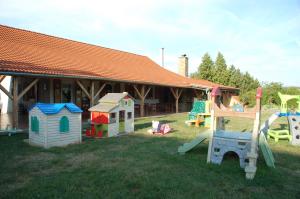 a group of play equipment in the grass in front of a house at Čarodějnický Dvůr in Biskoupky
