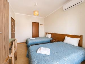 a hotel room with two beds and a sink at Arcádia by Umbral in Fátima +1 photo