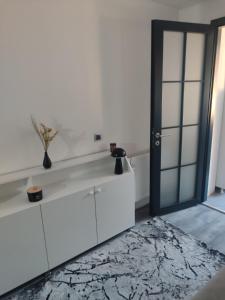 a living room with white cabinets and a black door at Lea Lux apartment Tuzla in Tuzla +36 photos