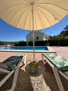 an umbrella sitting on a table next to two chairs at Cortijo Cenascuras in Priego de Córdoba