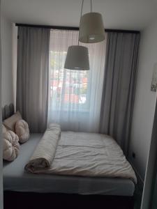 a bed in a bedroom with a window at Lea Lux apartment Tuzla in Tuzla
