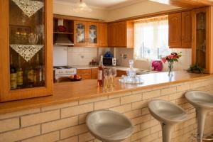 a kitchen with a counter with stools in it at Vasw Apartment in Ágios Nikólaos +10 photos