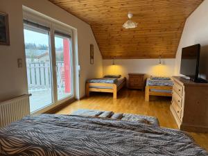 a bedroom with two beds and a large window at Dům Stašov in Stašov