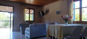 a living room with a table with a vase of flowers on it at Kaiti Villa 4 in Koukounaries