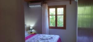 a bedroom with a bed and a window at Kaiti Villa 4 in Koukounaries