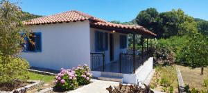 a small white house with a gate and flowers at Kaiti Villa 4 in Koukounaries