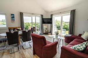 a living room with red furniture and a table at Haus JADEHUUS in Schweiburg