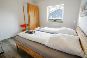 two twin beds in a room with a window at Haus JADEHUUS in Schweiburg