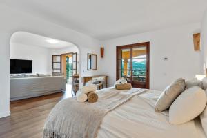 a white bedroom with a large bed and a television at Ca'n Cristofal in Felanitx +31 photos