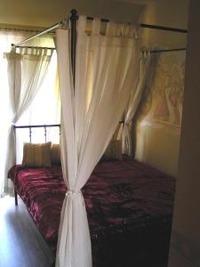 a bedroom with a canopy bed with curtains at Don Quijote Középkori Panzio és Étterem in Lenti