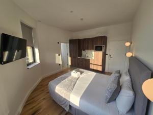 a bedroom with a large bed and a television at Ash Tree Hotel in Woolwich