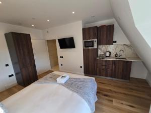 a bedroom with a large bed and a kitchen at Ash Tree Hotel in Woolwich +42 photos