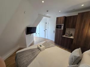 a bedroom with a large bed and a kitchen at Ash Tree Hotel in Woolwich