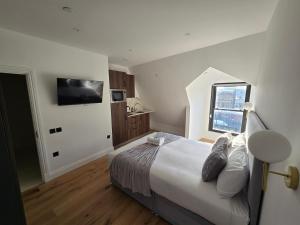 a bedroom with a large bed and a television at Ash Tree Hotel in Woolwich