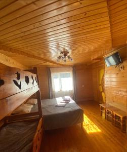 a bedroom with a bed in a wooden cabin at TaVa House 2 in Yaremche