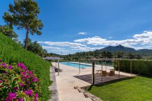 a garden with a swimming pool and purple flowers at Ca'n Cristofal in Felanitx