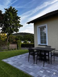 a patio with a table and chairs in a yard at Ferienwohnung NERA in Gelnhausen