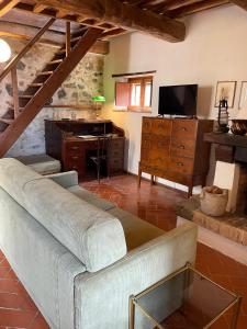 a living room with a couch and a desk and a television at Casa con Piscina Climatizzata - Vecchia Stalla in Casa Montacuto