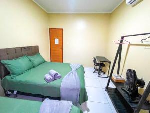 a bedroom with a green bed and a desk at Casa em Condomínio, Jardim, Home Office in Castanhal
