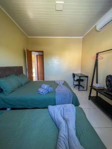 a bedroom with a bed with towels on it at Casa em Condomínio, Jardim, Home Office in Castanhal +45 photos