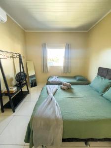 a bedroom with a green bed and a window at Casa em Condomínio, Jardim, Home Office in Castanhal