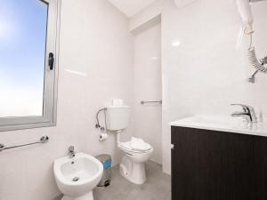 a white bathroom with a toilet and a sink at Arcádia by Umbral in Fátima