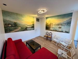 a living room with a red couch and a painting on the wall at Duplex sympa Verviers in Verviers